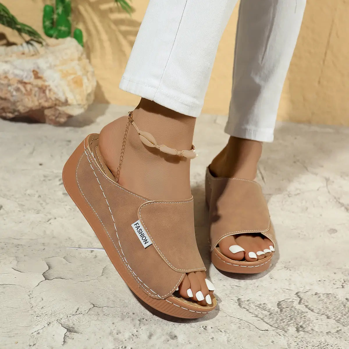 Sandales d’été à plateforme compensée à bride glissante pour femmes en daim beige, avec une semelle massive et une bride de cheville décorative.