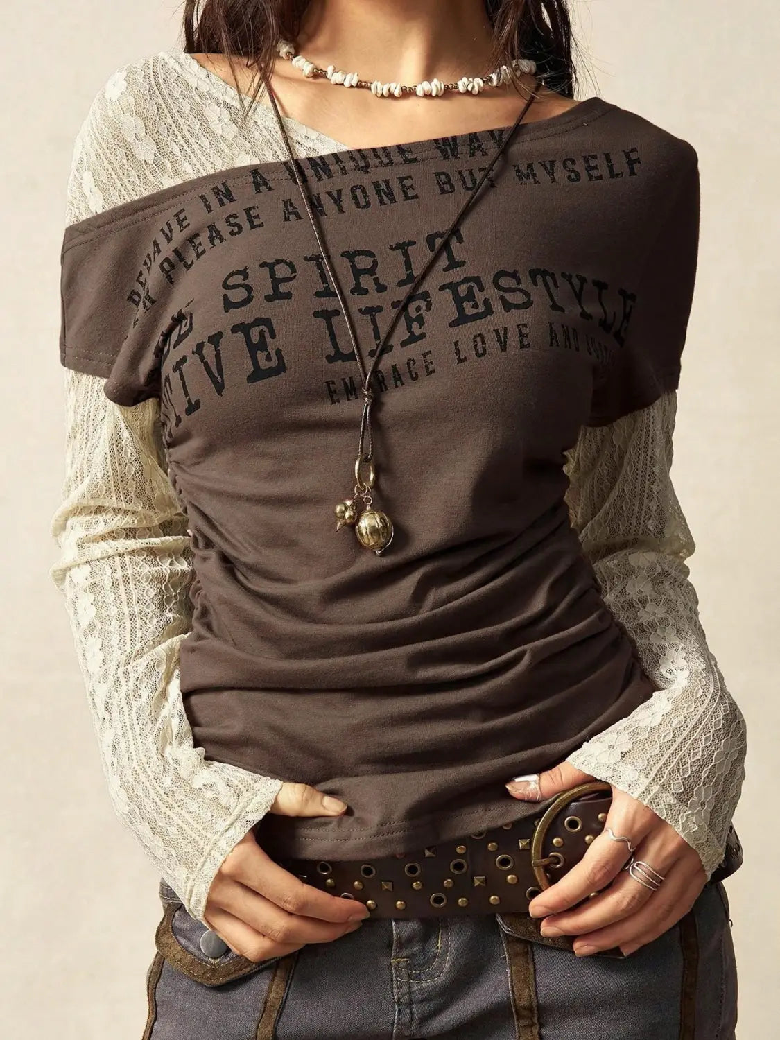 Brown lace layer off shoulder knitted top featuring graphic black lettering and lace long sleeves.