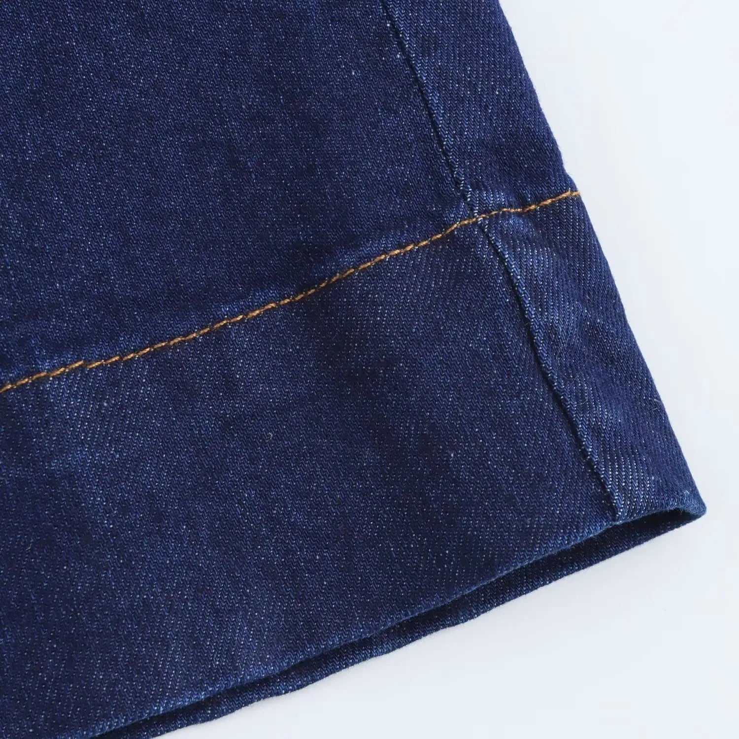navy crew neck sleeveless denim a-line dress featuring deep blue denim fabric with contrasting tan stitching along the seam.