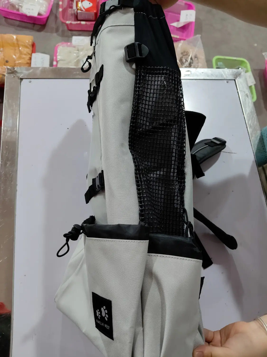 a sleek light gray and black breathable dog backpack mesh pet carrier featuring a mesh side pocket and multiple adjustable straps