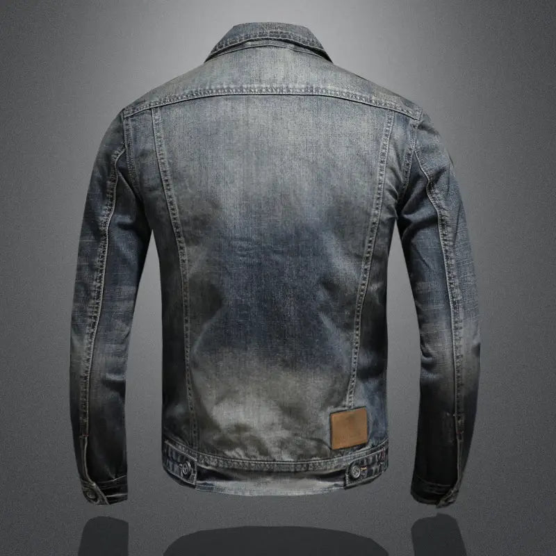 A faded dark blue distressed denim jacket for men featuring a classic collar and visible stitching.