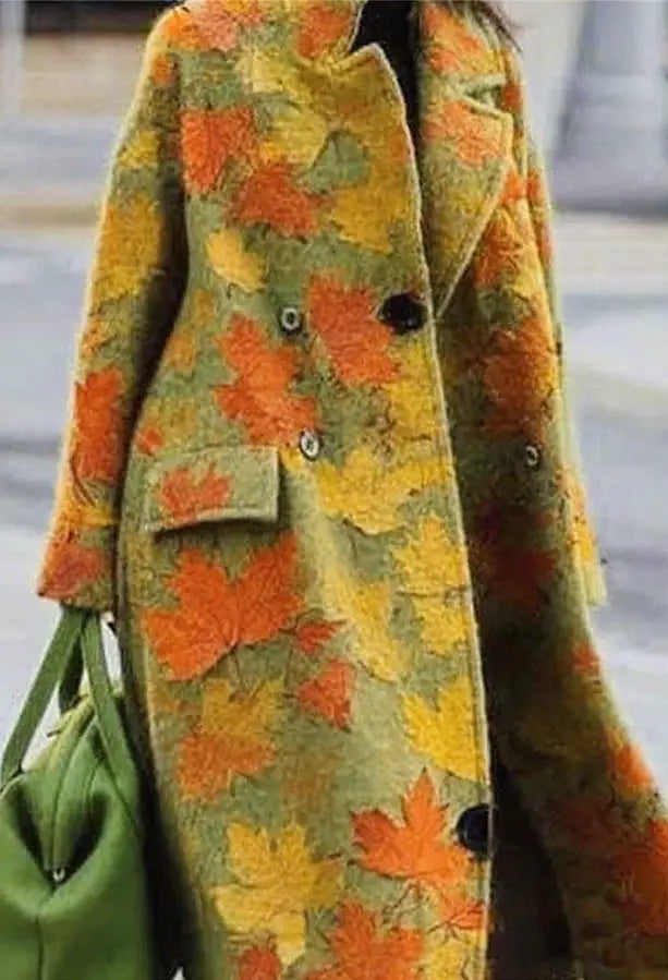 Ein gemütlicher bestickter Wollmantel für Damen mit einem lebendigen Herbstblattmuster in Orange- und Gelbtönen auf olivgrünem Hintergrund.