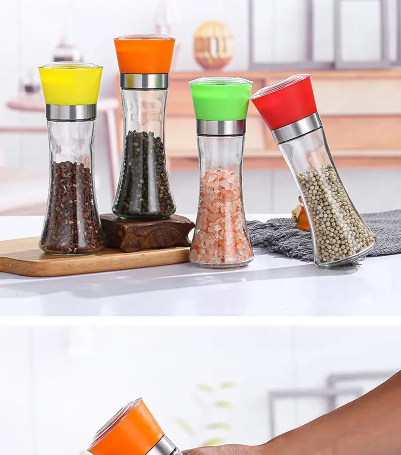 Lot de quatre moulins à poivre et à sel en verre coloré, avec des embouts en silicone vifs jaune, orange, vert et rouge, en matériaux acier inoxydable et verre, pour l’assaisonnement.