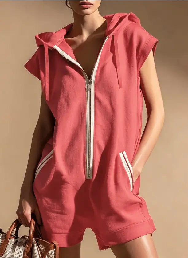 A coral pink sleeveless hooded romper with a white half zipper and white side stripes featuring front pockets.