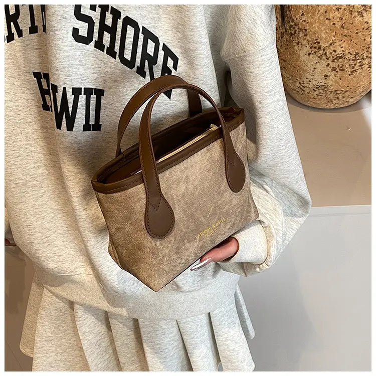 Beige canvas mini tote retro bucket bag with brown leather handles and trim featuring textured canvas for shoulder handbag use.
