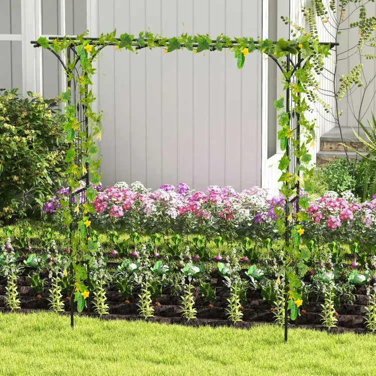 Black metal garden arbor archway measuring 81 inches adorned with green vines and yellow flowers designed for climbing plants.