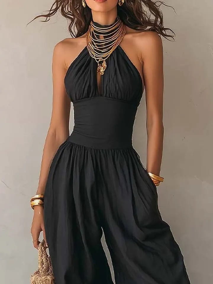 Mono tipo halter de pierna ancha en color negro con cuerpo ceñido y pantalones de pierna ancha con caída fluida en tejido negro.