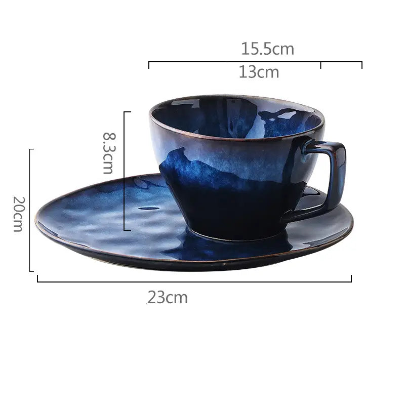 Ceramic coffee mug and saucer set in deep blue glaze featuring a gradient finish from dark to light shades with a subtle textured ceramic surface.