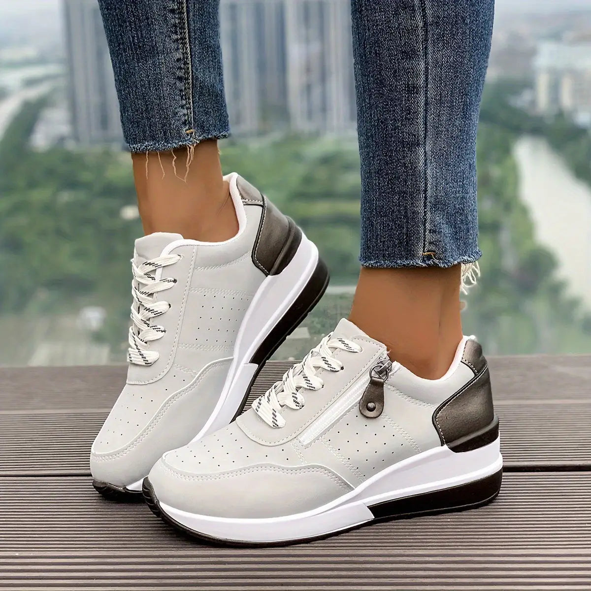 Baskets à plateforme pour femmes en cuir synthétique blanc et gris, avec dessus perforé, semelles en caoutchouc noires et détail de fermeture éclair latérale pour un port décontracté.