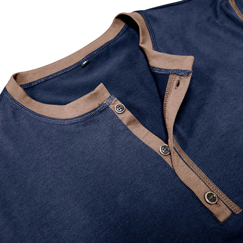 Navy blue cotton contrast trim short sleeve henley polo shirt with tan ribbed collar and placket featuring metallic buttons.