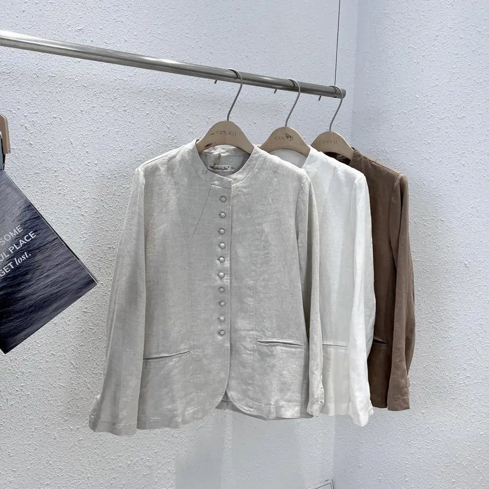 Eine hellgraue Leinen-Patchworkjacke mit Rundhalsausschnitt und Knopfverschluss in relaxedem Schnitt.