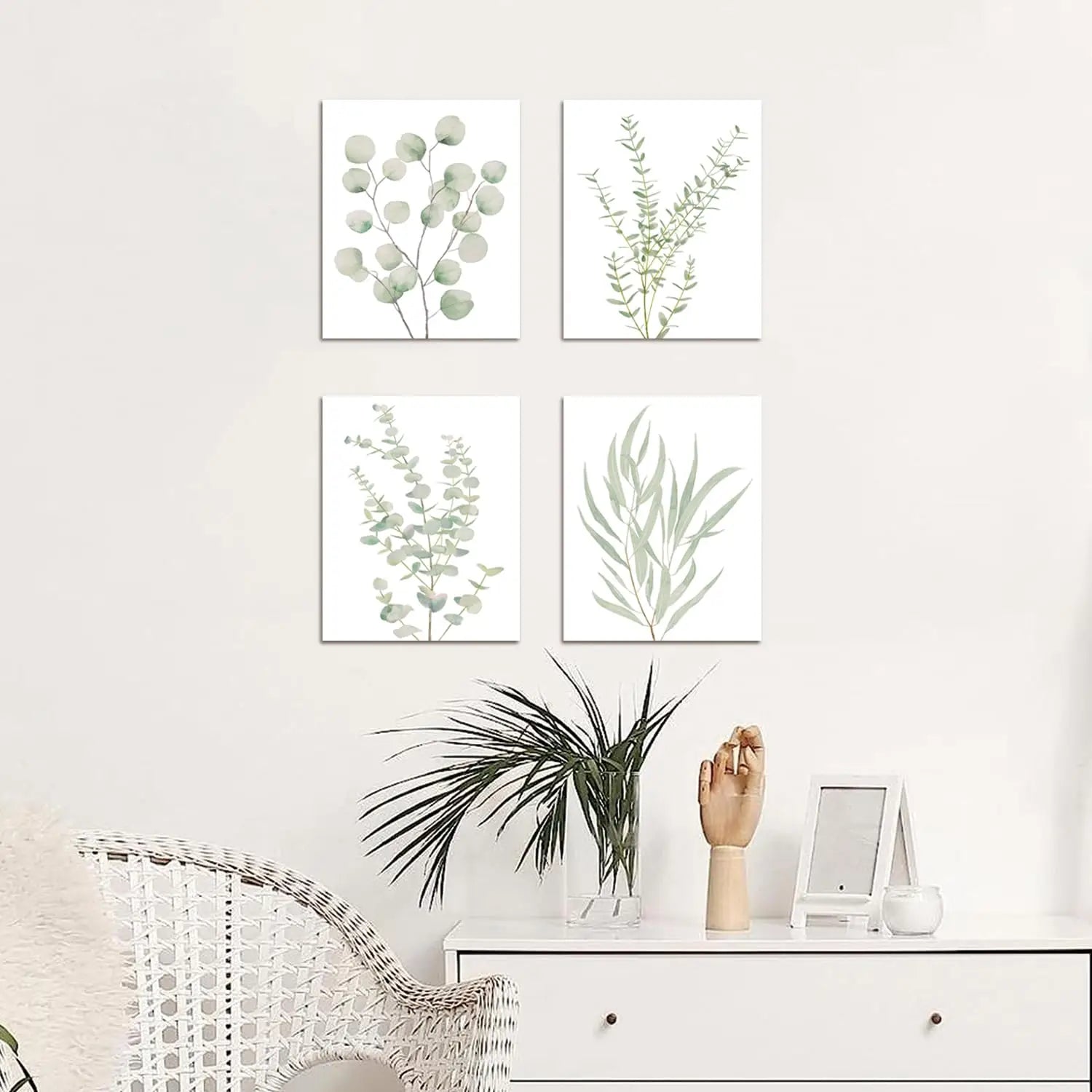 Set of four minimalist botanical canvas wall art prints featuring delicate green eucalyptus foliage on white backgrounds in framed decor.