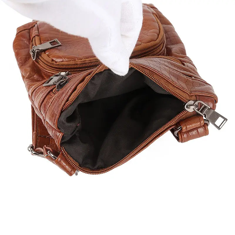 Brown quilted faux leather retro crocodile textured soft crossbody bag with black interior lining and silver-toned zippers.