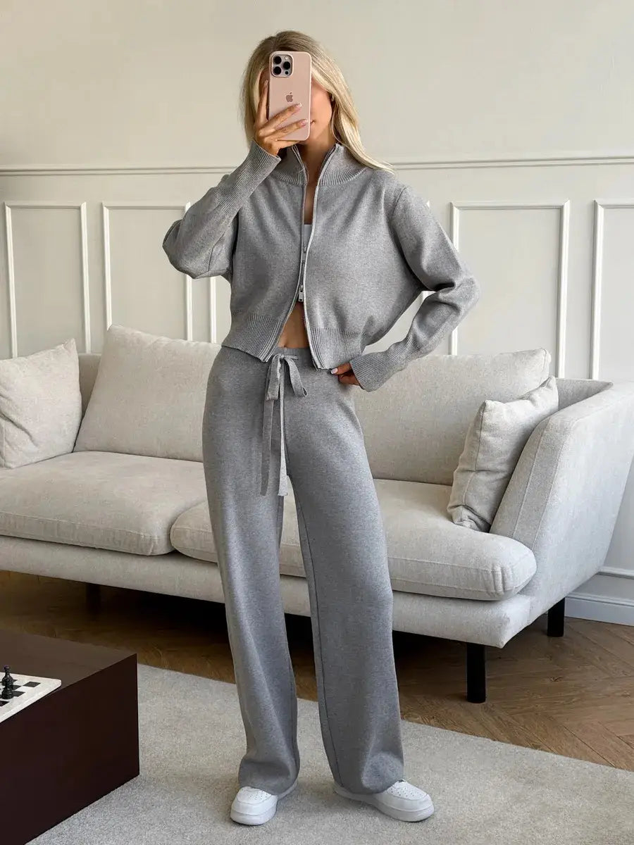 Woman wearing a gray knit zip up cardigan and wide leg pant set featuring a matching cropped jacket and wide-leg pants with a drawstring waistband.