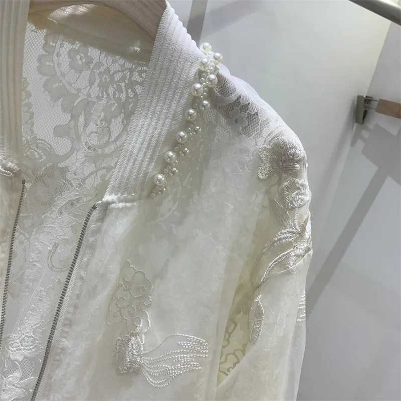 肩に沿って、精緻なシルバー刺繍とパール装飾を施した繊細なホワイトレース素材のアイボリーのレースパール刺繍ボンバージャケット。