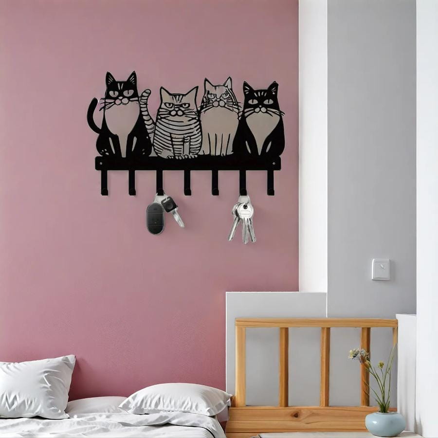 Black metal wall-mounted key rack featuring four stylized black cats with distinct expressions and patterns for home decor with four hooks.