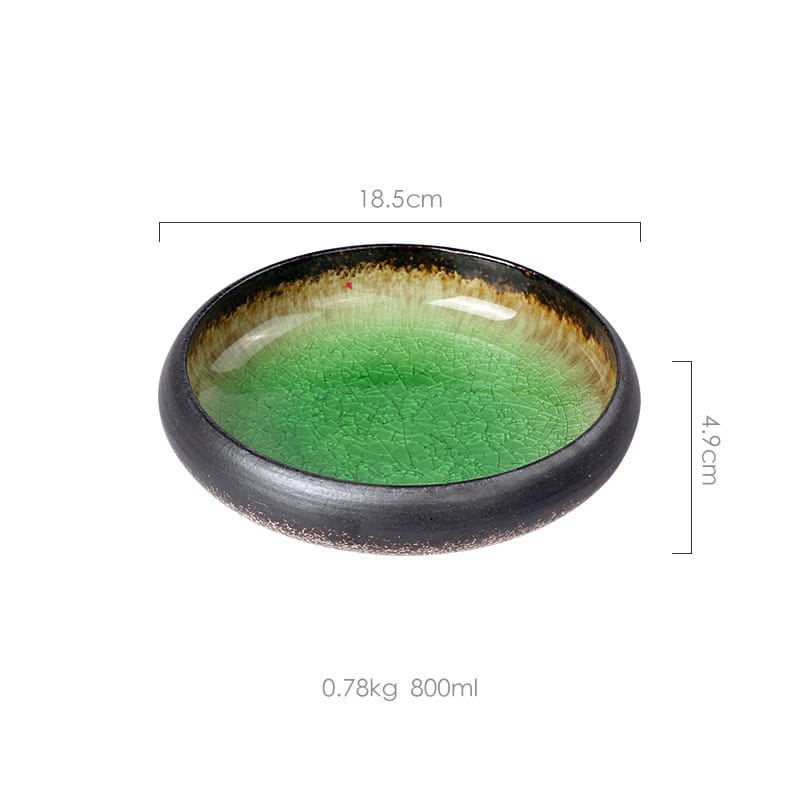 A handcrafted ceramic bowl with a vibrant green crackle glazed interior and dark brown rim and base made of kiln glazed bone china.