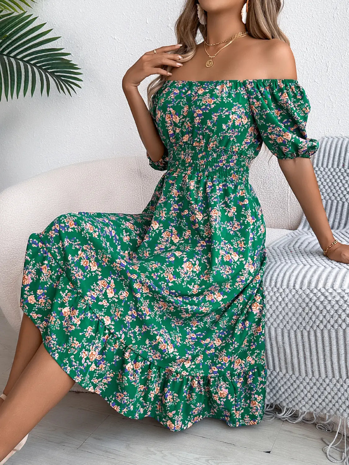 Robe midi décolletée vert vif avec motif floral aux tons rose pâle, violet et blanc, avec des manches bouffantes et des détails à volants, idéale pour l’été.