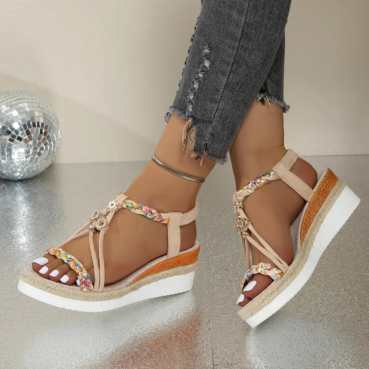 Sandalias tipo cuña beige para mujer con bailarinas tipo espadrille tejidas que presentan adornos florales coloridos en las correas.