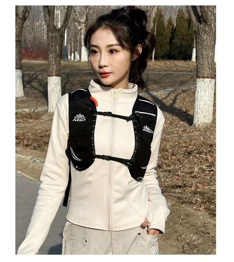 Black azeal hydration backpack lightweight running vest 20l with mesh panels and adjustable straps worn over a cream-colored zip-up jacket.
