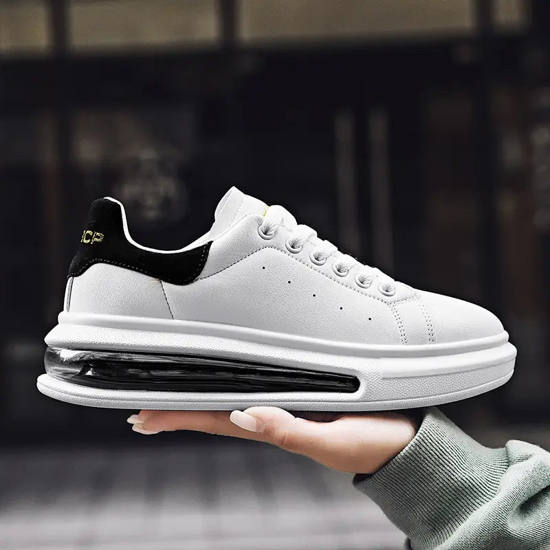 Weißer Sneaker mit schwarzen Akzenten und einer transparenten Air-Cushion im Sohlenbereich mit Obermaterial aus PU-Leder und einem eleganten Design für sportliche Zwecke.