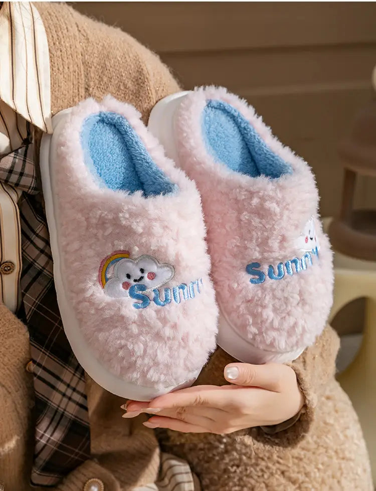 pink fluffy plush cotton slippers with blue interior and embroidered cloud design featuring the word sunny from smiling cloud and rainbow collection