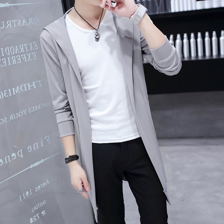 Abrigo tipo capa con capucha, de frente abierto y corte ajustado para hombre, en color gris, con un diseño moderno y elegante y aberturas laterales sutiles.