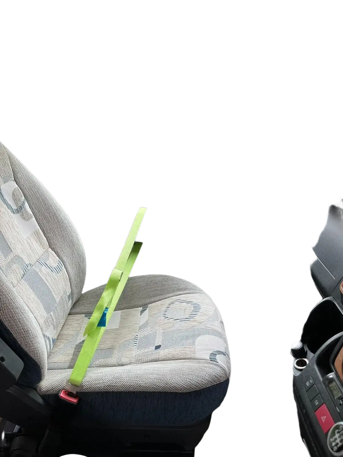 A bright lime green cab lok motorhome seat strap with a red buckle on a patterned van passenger seat fabric