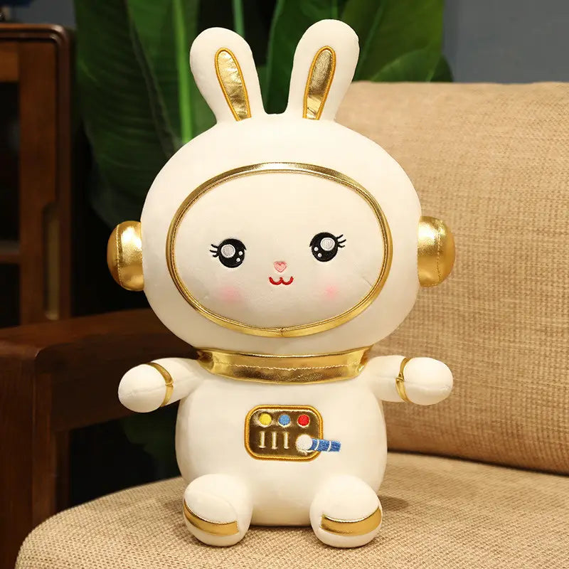 白いふわふわの宇宙飛行士のウサギぬいぐるみで、耳・ヘルメット・手足に金のアクセントがあり、宇宙ウサギのような意匠のぬいぐるみ。