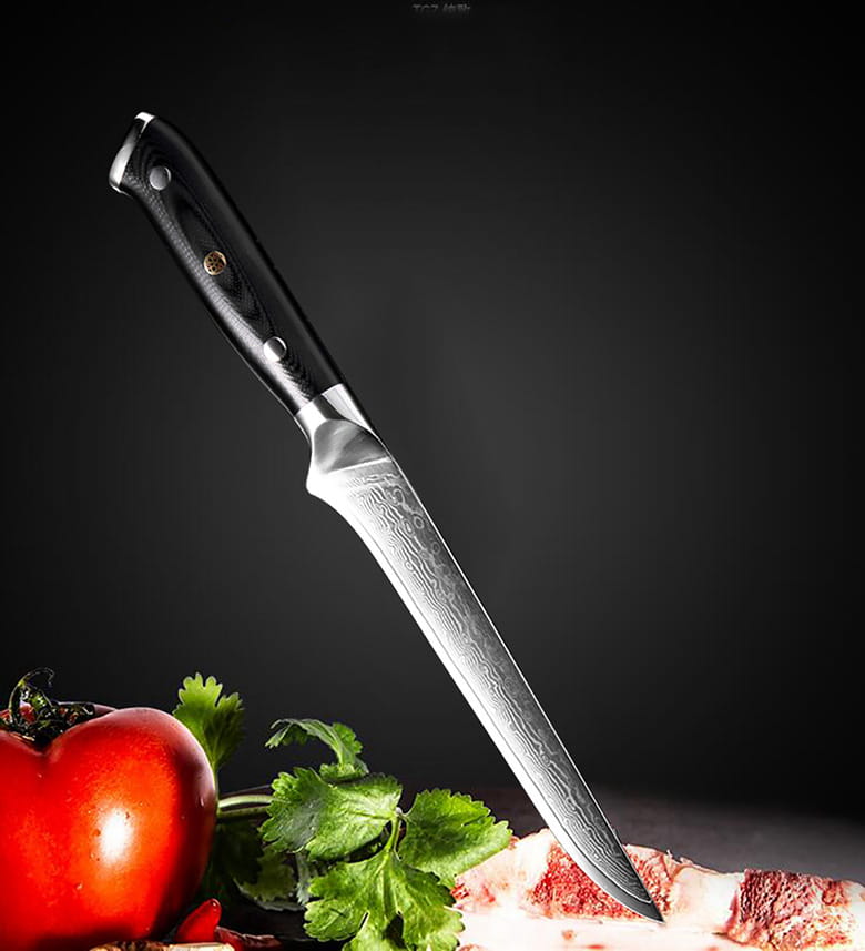 Ein elegantes Kochmesser mit schwarzem Griff und einer Klinge aus Damaststahl, das neben rohem Fleisch auf frischen Kräutern und einer Tomate ruht, Teil des Damaststahl-Küchenmesserset 4-teilig, G10-Griff.