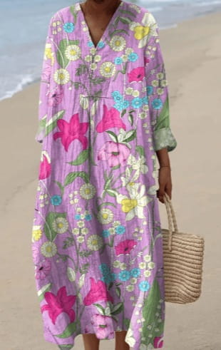 Women’s abstract v neck patterned maxi dress in flowing lavender fabric with vibrant pink yellow and blue floral blossoms.