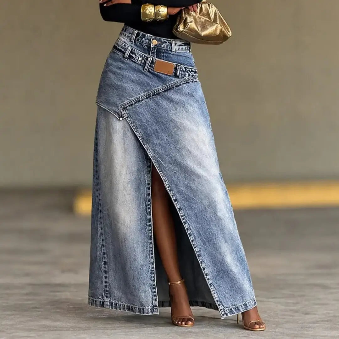 Ein High-Waist-Denim-Maxirock mit asymmetrischem vorderem Schlitz, hellblauem Ausbleichen und klassischer Steppnaht.