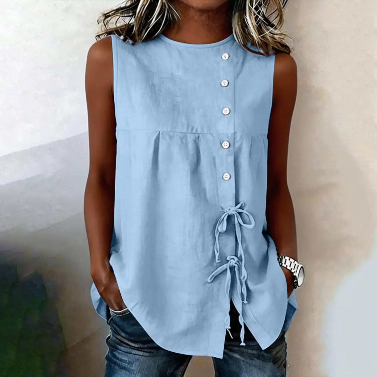 Light blue sleeveless tie side button down blouse featuring a button-front closure and side tie details.
