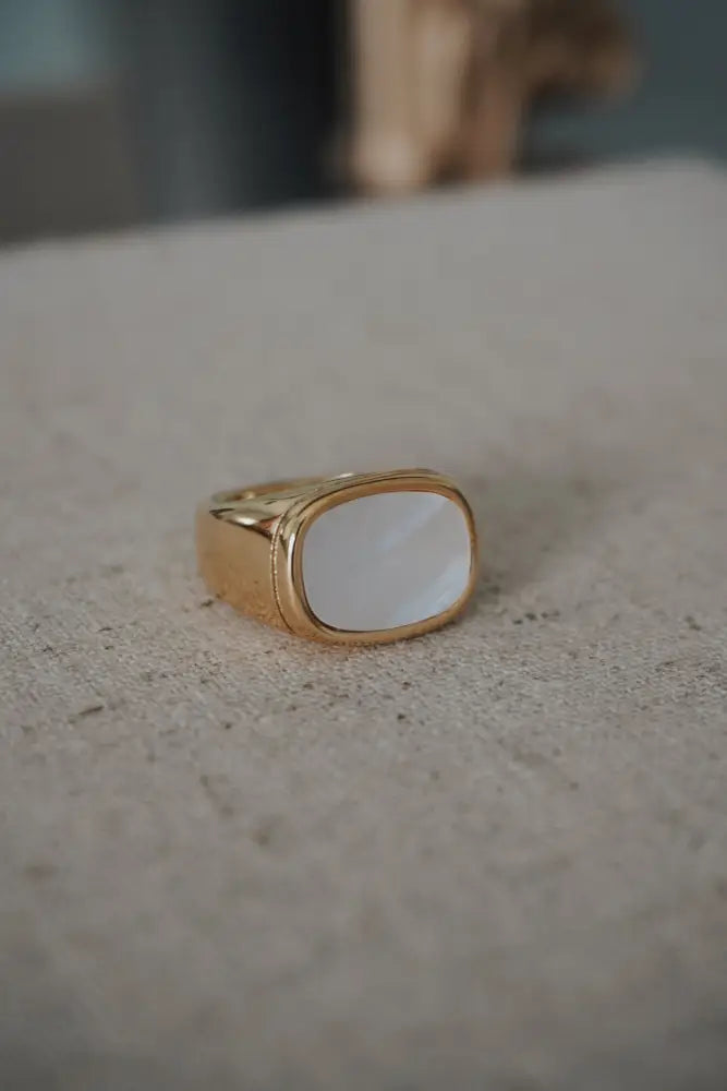 Calypso gold signet ring featuring a rectangular smooth white mother of pearl inlay and gold-toned finish