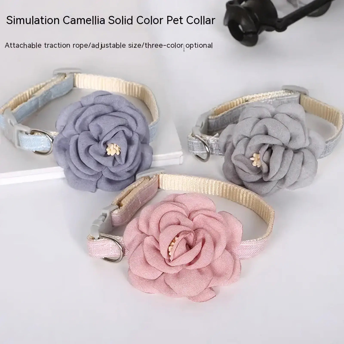 Three adjustable cat collars featuring large fabric camellia flower centerpieces in lavender gray and pink solid colors