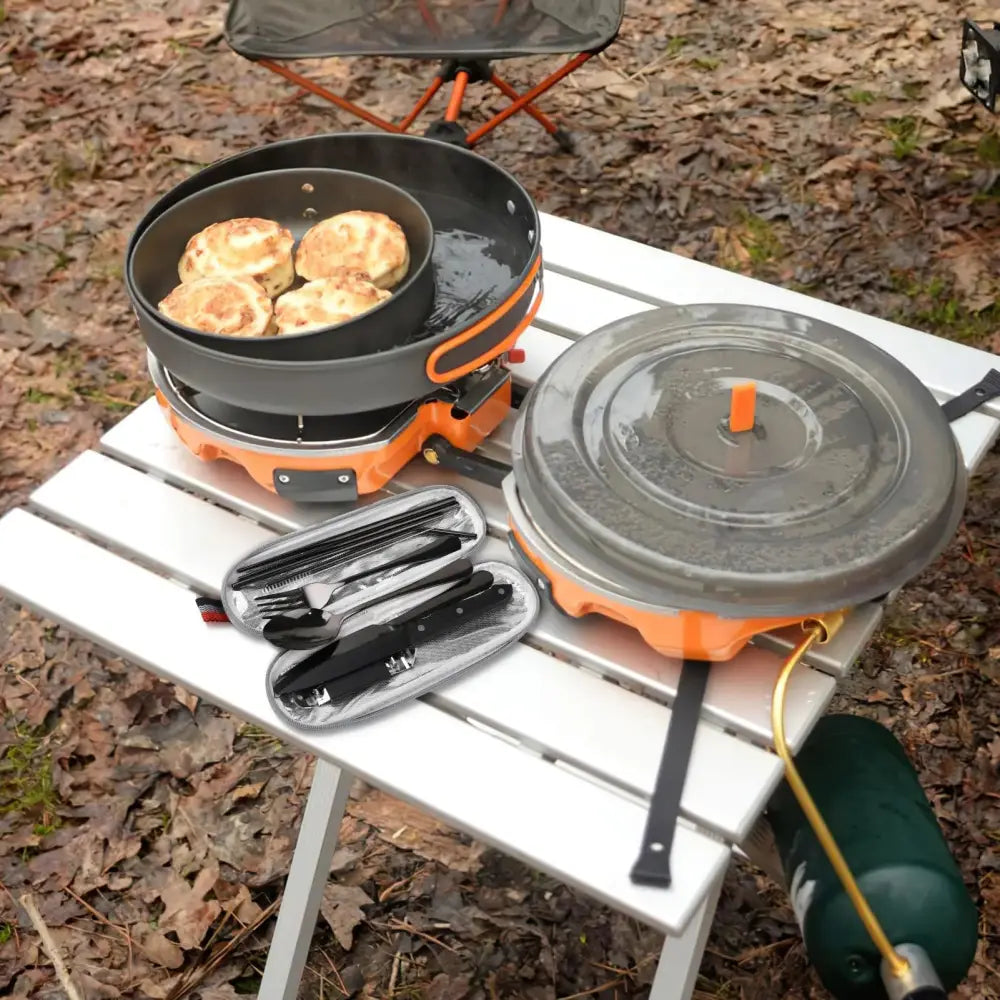 Orange portable camping stove with black frying pan and lid included in 9-piece stainless steel camping cutlery set
