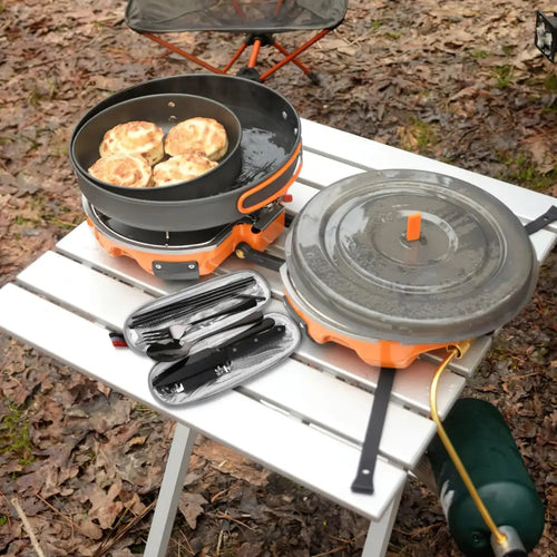 Orange portable camping stove with black frying pan and lid included in 9-piece stainless steel camping cutlery set