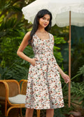 A woman wears a sleeveless campsite print vintage fit and flare cotton dress with colorful cartoon animals