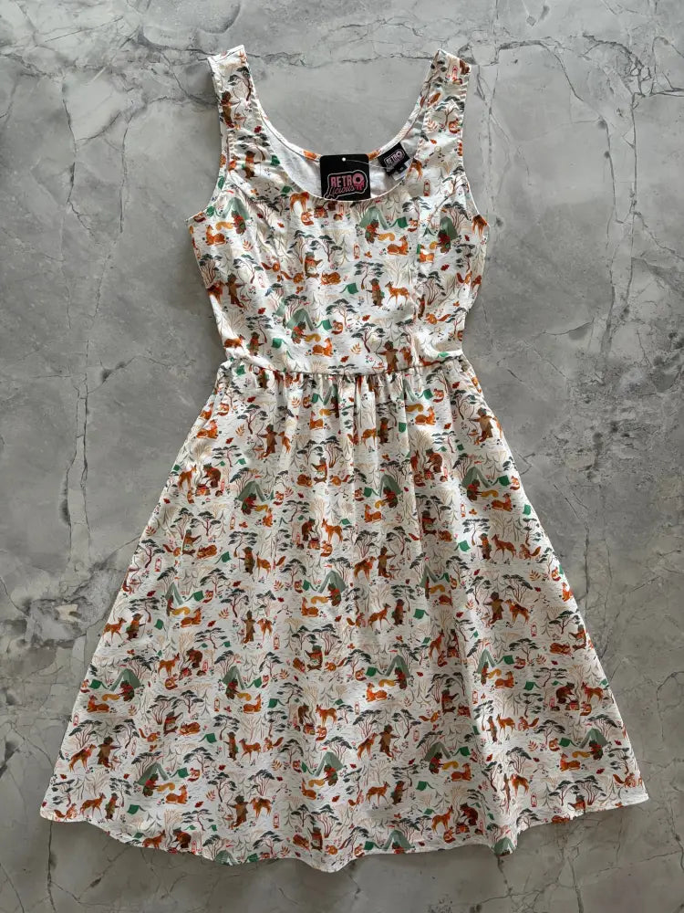 A white sleeveless cotton fit and flare dress with a playful brown and green campsite animal print