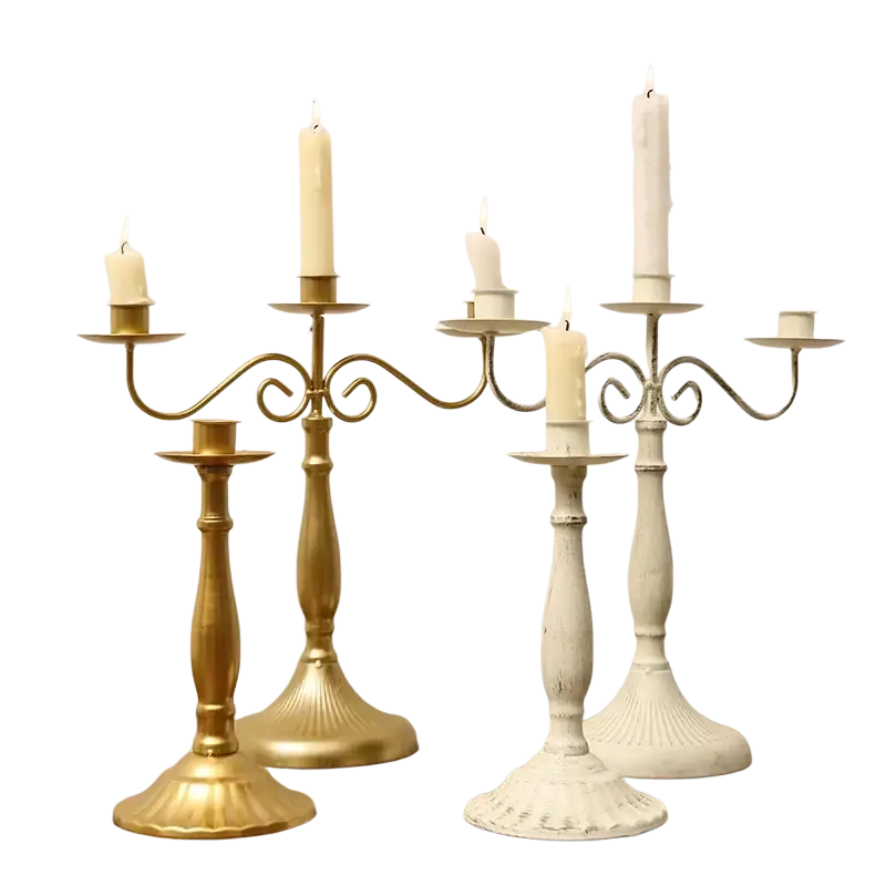 Gold and white metal candle holders with ornate scrolled arms and fluted bases for table decorations modern european hotel wedding