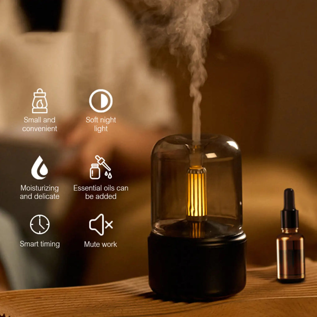 A sleek black and transparent glass candle light aroma diffuser usb humidifier with glowing vertical led and soft mist