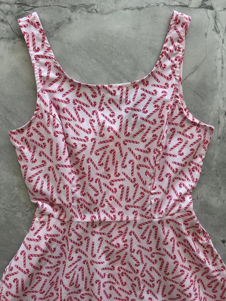 A white sleeveless candy cane stripe a-line skater dress with pockets featuring a red and white candy cane pattern
