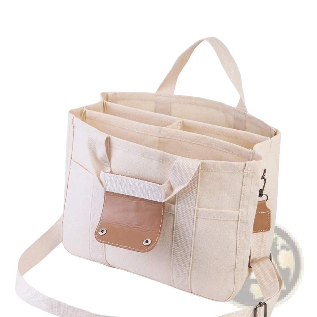 Beige canvas messenger bag with tan leather accents and multiple compartments for mother and baby travel use