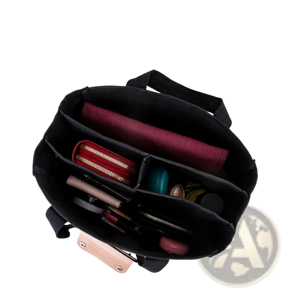 Black fabric organizer with compartments holding makeup and red pouch inside canvas messenger bag mother and baby tote
