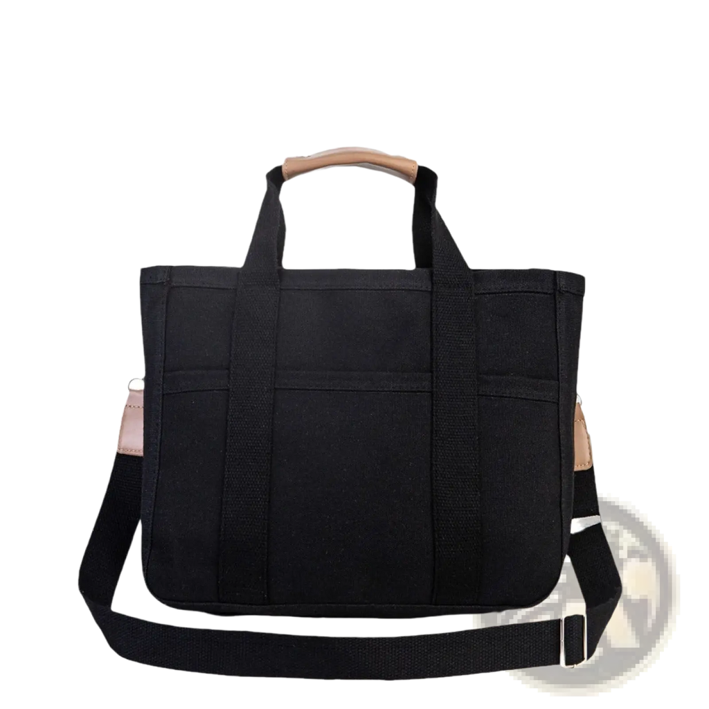 Black canvas messenger bag with tan leather handles and shoulder strap accents for mother and baby travel tote