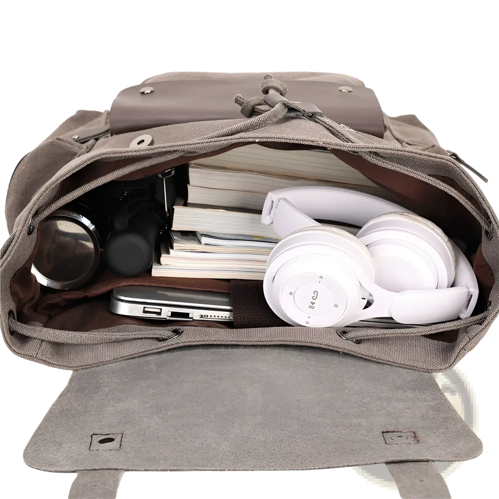 Gray canvas retro backpack with large capacity, drawstring closure, leather flap, filled with books and tech gear