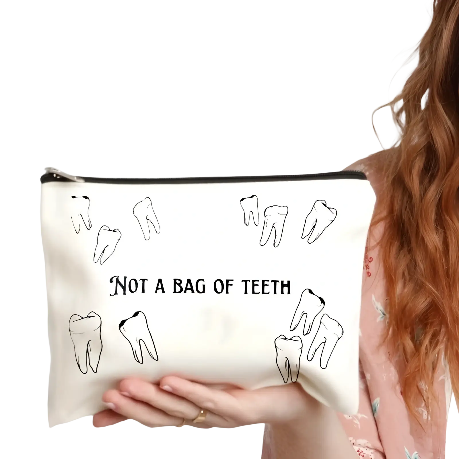 White canvas makeup bag with black tooth illustrations and text not a bag of teeth for travel storage