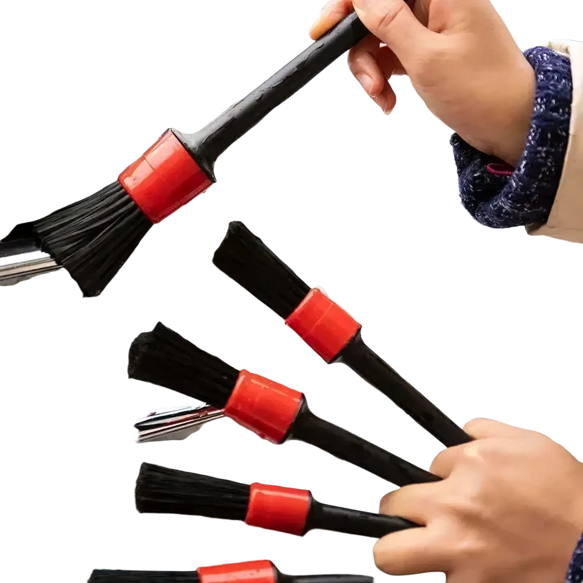 Black car detailing brushes with red plastic handles and nylon bristles cleaning a soapy chrome grille