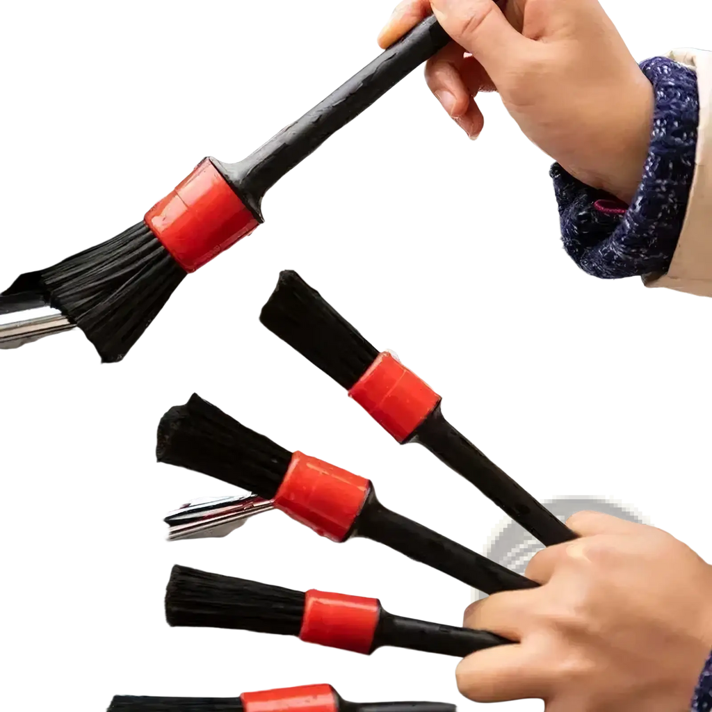 Black car detailing brushes with red plastic handles and nylon bristles cleaning a soapy chrome grille