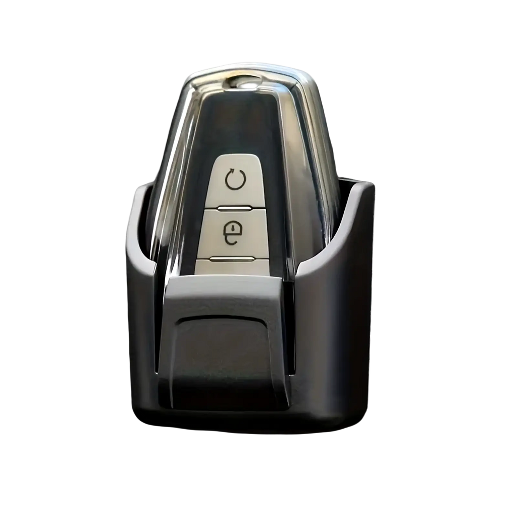 Chrome-finished car key fob with two buttons housed in sleek black plastic car key organizer dashboard storage box